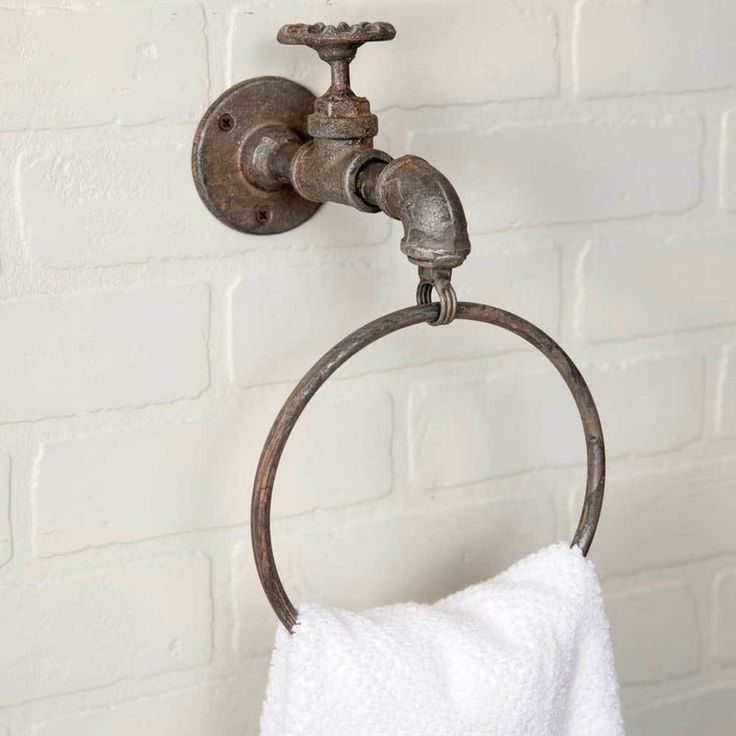 an old fashioned towel ring is hanging on the wall next to a white brick wall