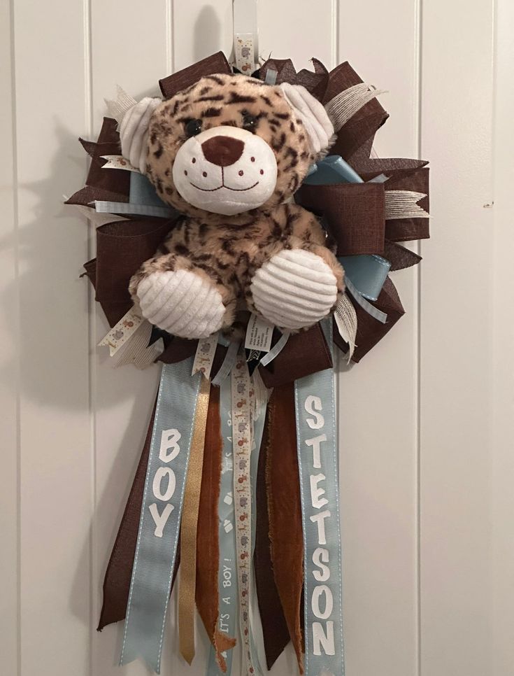 a stuffed animal hanging from the side of a door with ribbon around it's neck