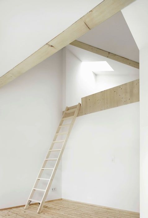 an empty room with a ladder to the ceiling