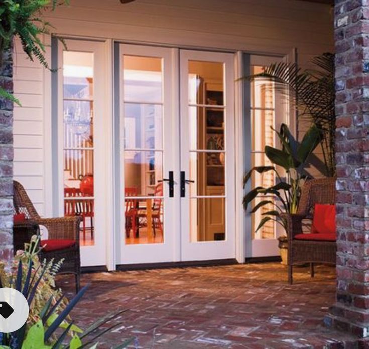 an open patio with white doors and brick walls