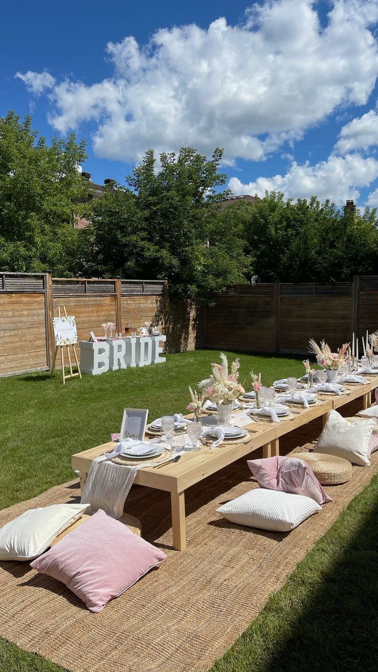 a table set up with place settings and flowers in vases on the tables outside