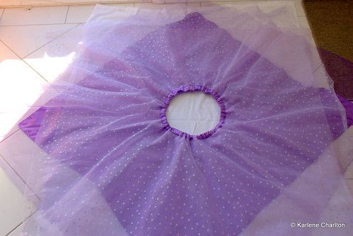 a purple umbrella sitting on top of a tile floor next to a white tiled floor