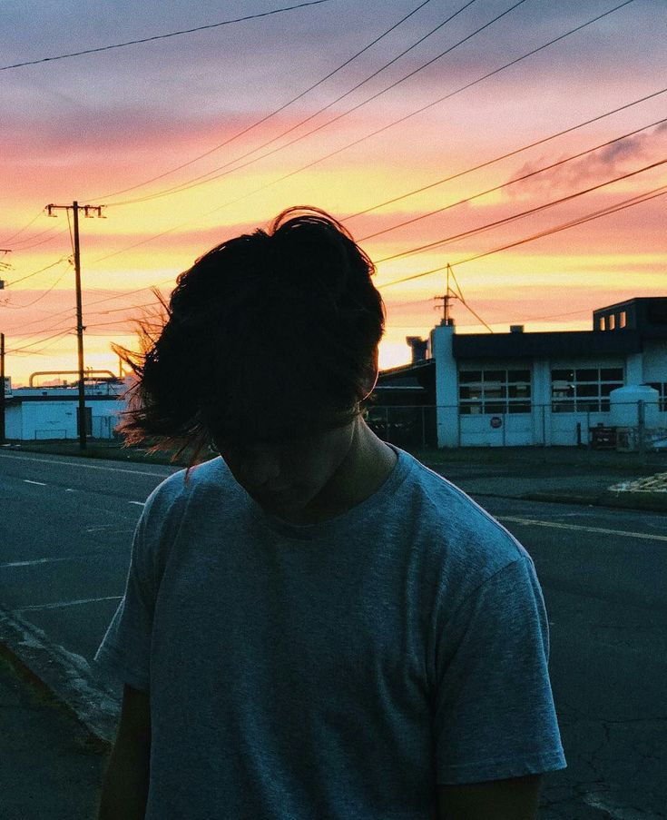 a person walking down the street at sunset