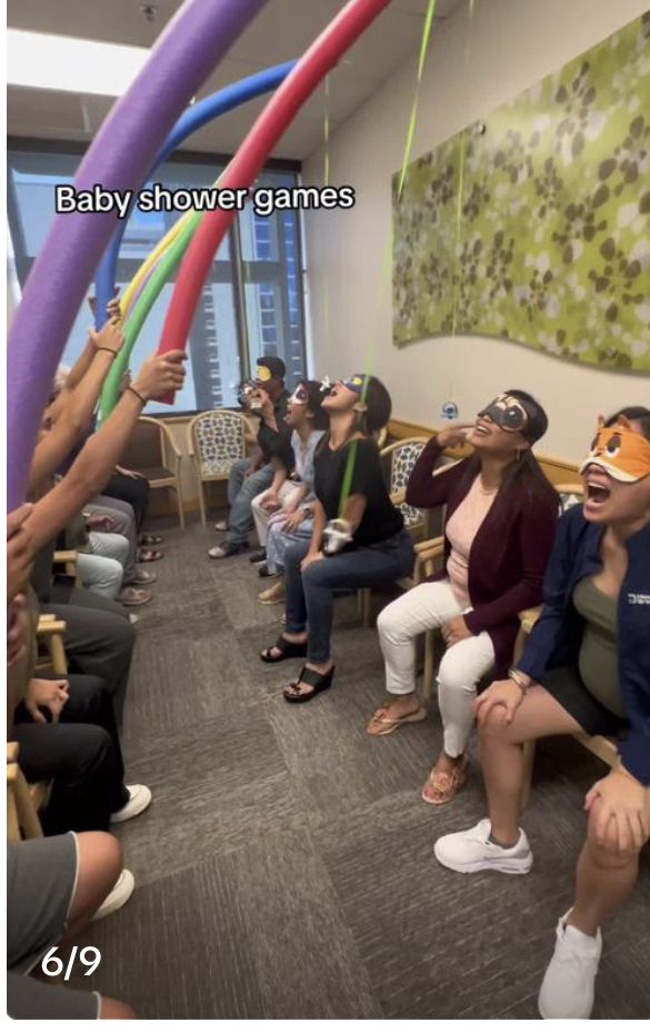 a group of people sitting in a room with balloons and blindfolds on their eyes