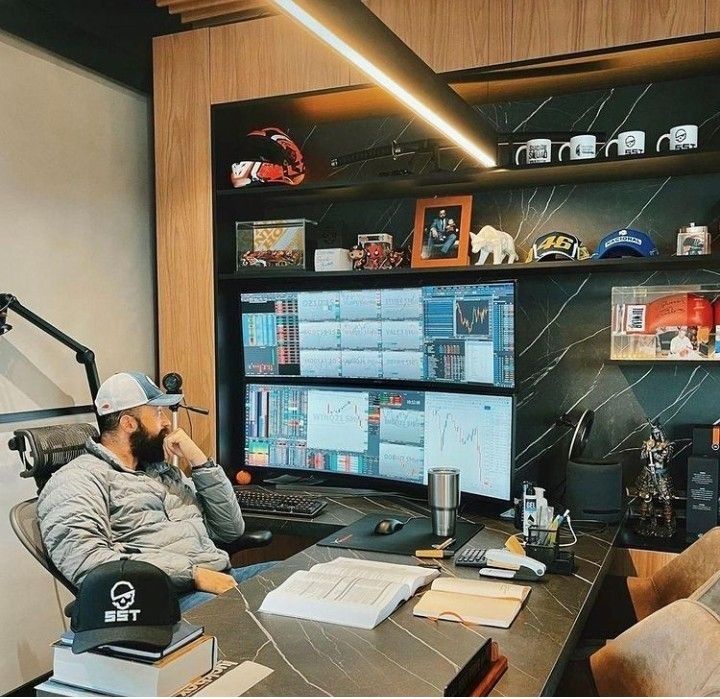 a man sitting at a desk in front of two computer monitors