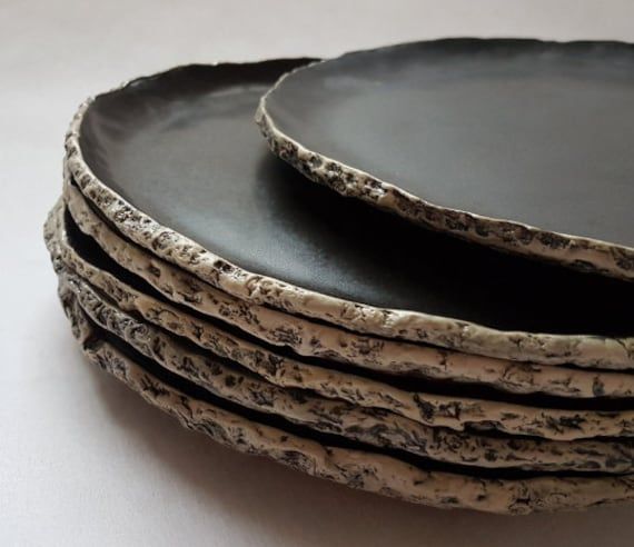 a stack of black plates sitting on top of each other