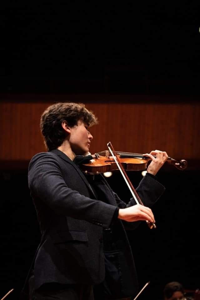 a man in a suit playing the violin