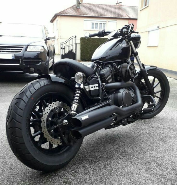 a black motorcycle parked in front of a house