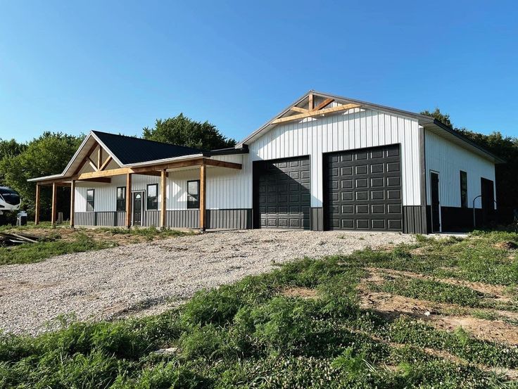 a two car garage sitting in the middle of a field