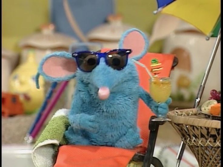 a blue stuffed mouse wearing sunglasses sitting in a chair