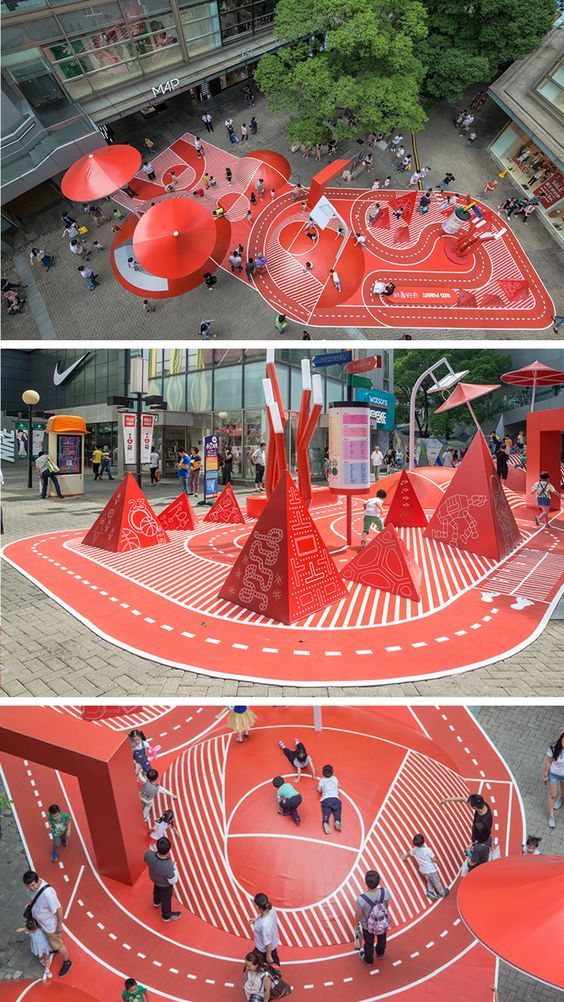 an aerial view of a red playground with people playing in it and on the ground