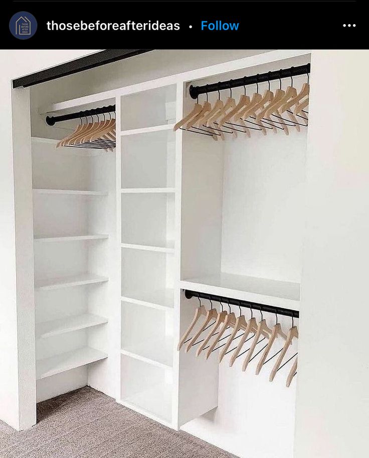 an open closet with white shelves and wooden hangers