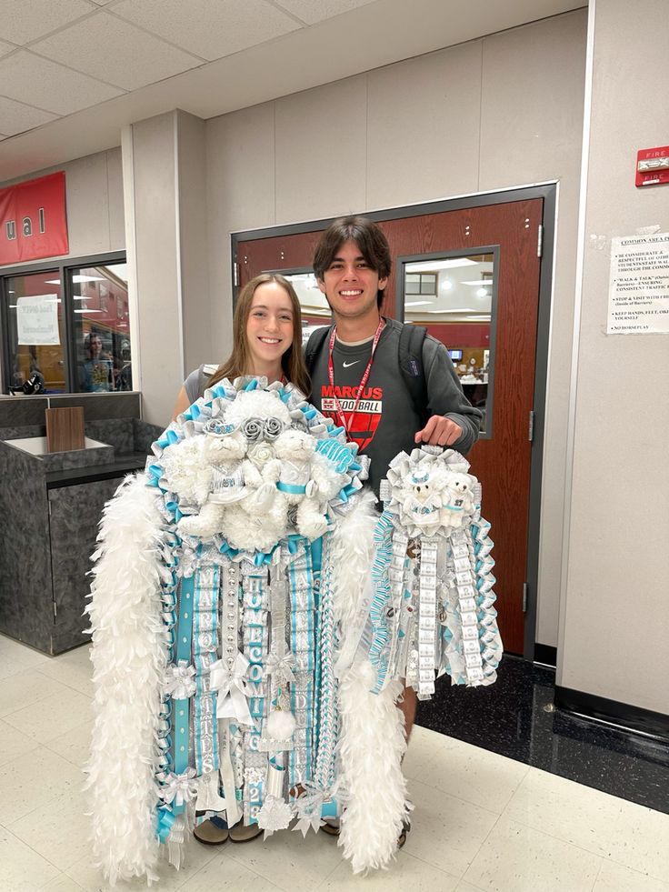 a man and woman standing next to each other in front of a table with decorations on it