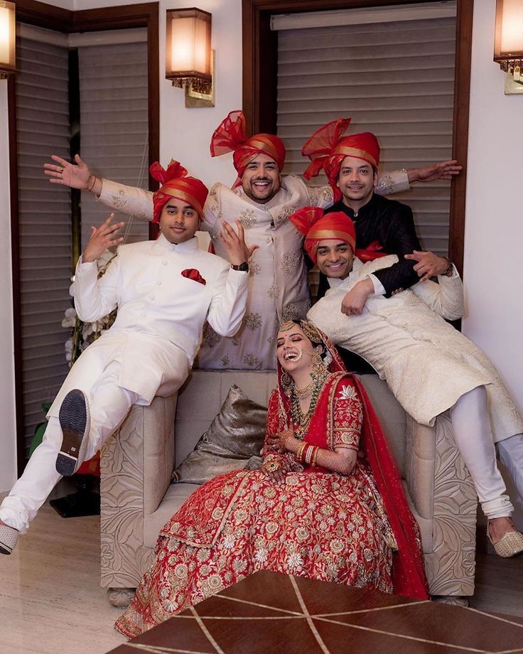 a group of people sitting on top of a couch in front of each other wearing red and white outfits