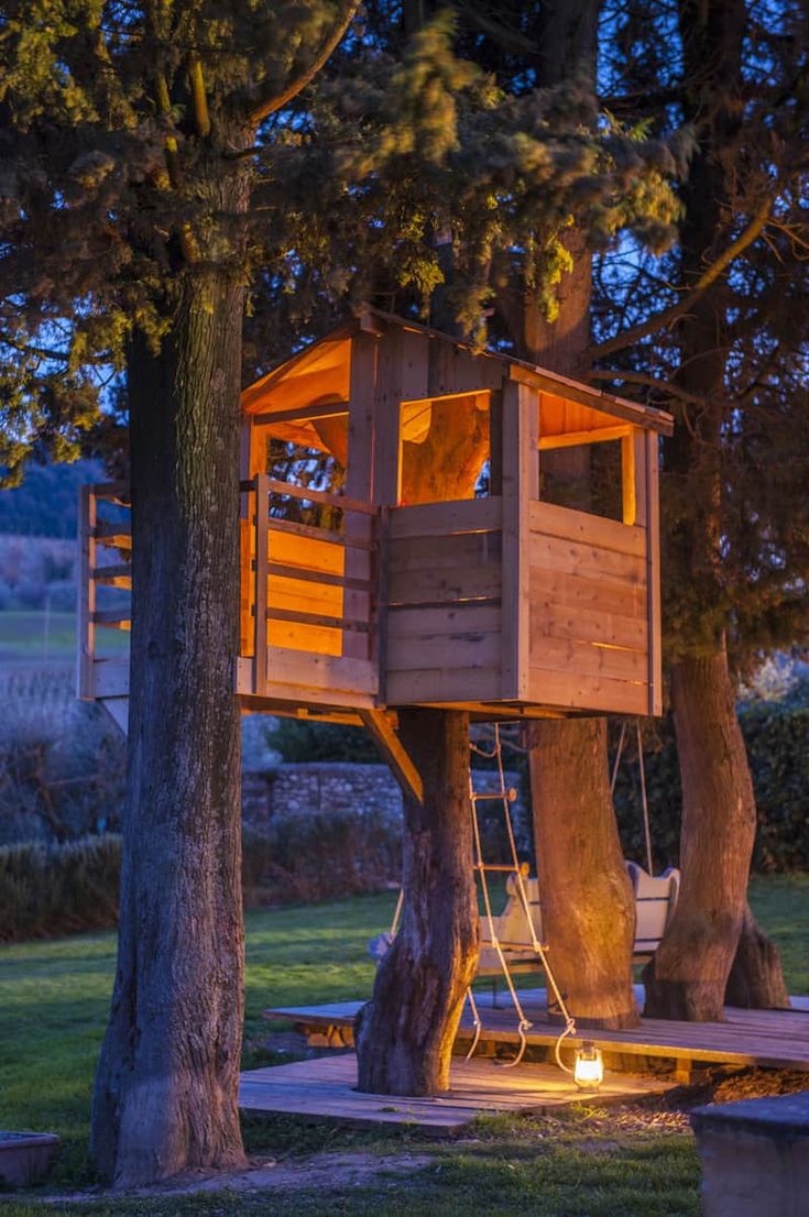 a tree house is lit up at night