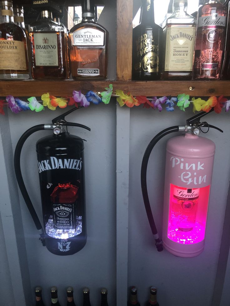 two lighted bottles are on the wall next to each other