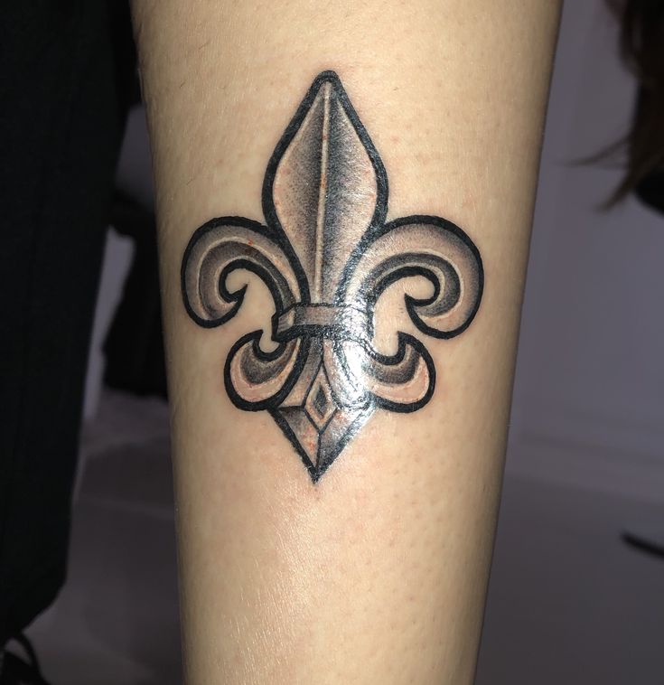 a black and grey tattoo with a fleur de lis on it