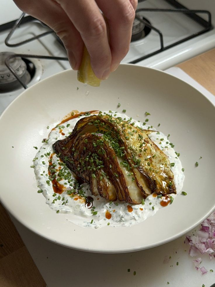 a person is dipping some kind of sauce on top of food in a white bowl