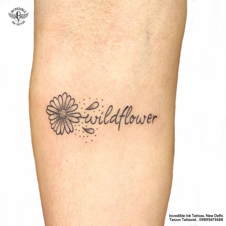 a tattoo with the words wildflower written in cursive font and a flower