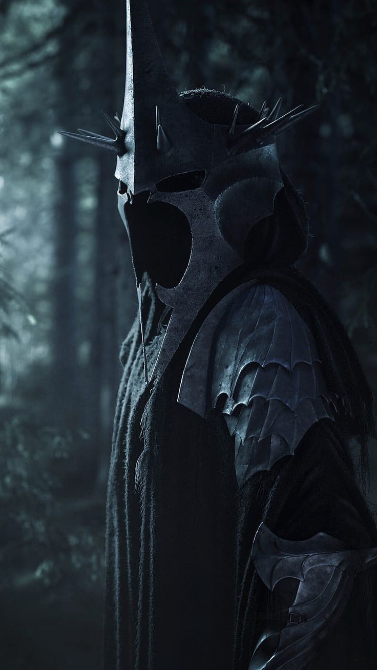 a man in a dark forest wearing a mask and holding a knife with both hands