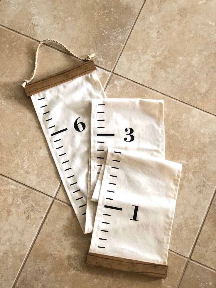 three measurings on the floor with rope hanging from each one's sides and numbers printed on them