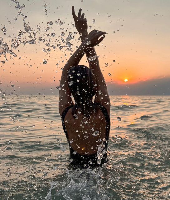 a person standing in the water with their arms up