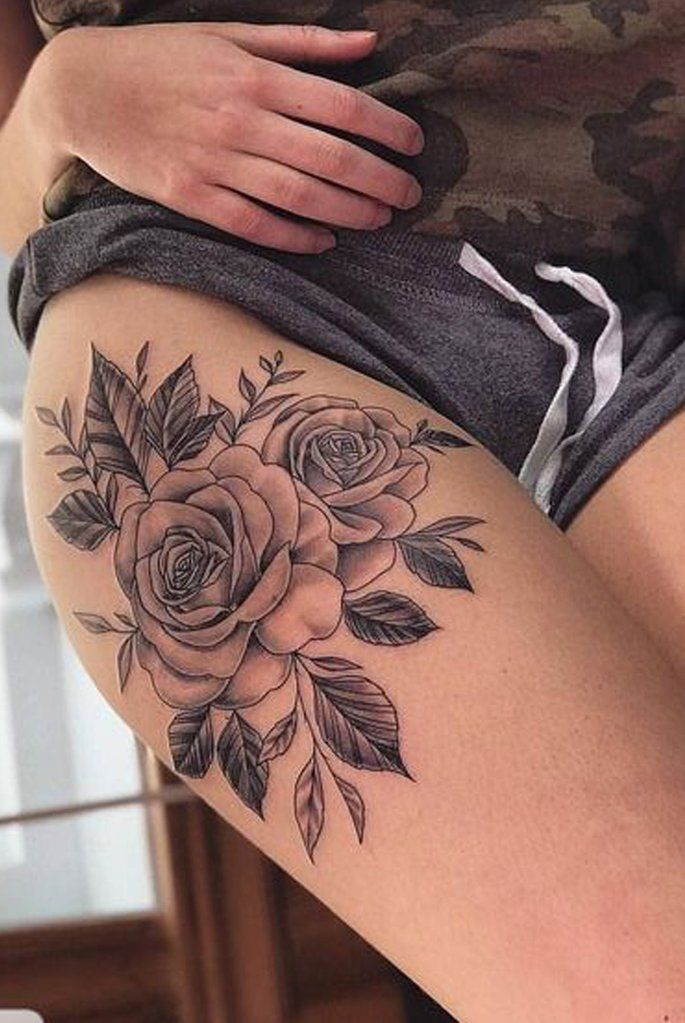 a woman's thigh with roses on it and leaves in the bottom half of her thighs