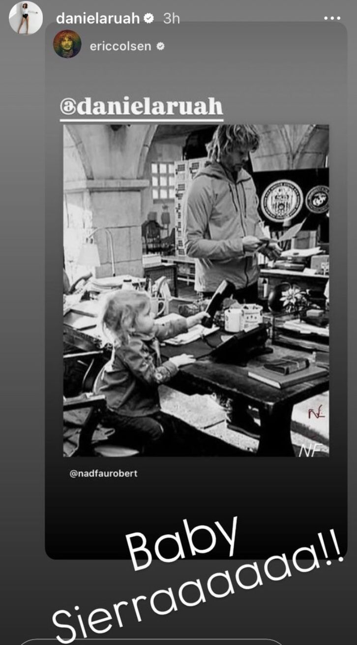 an image of a baby sitting at a table in front of a man on the phone