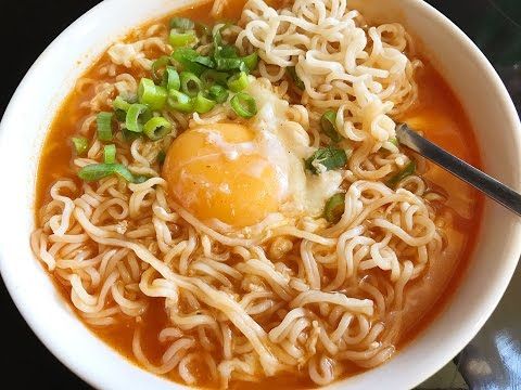 a white bowl filled with noodles and an egg