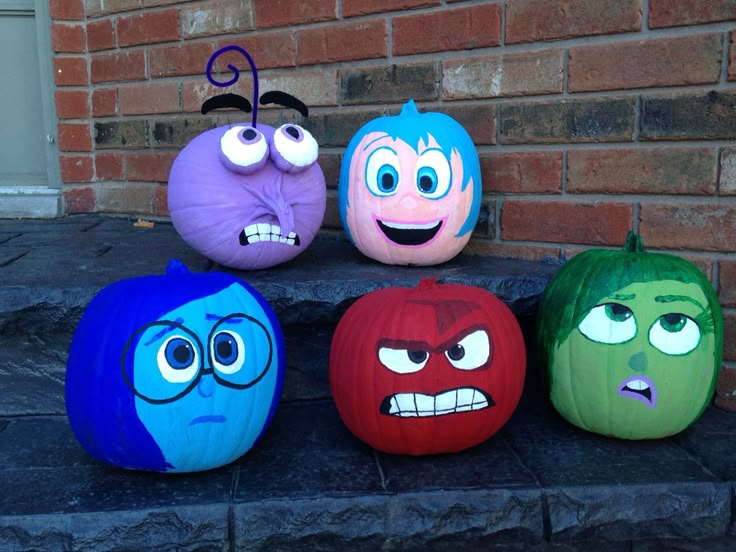 four pumpkins painted to look like cartoon characters