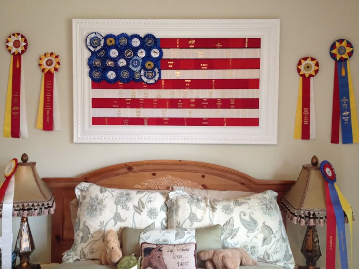 an american flag is hanging on the wall above a bed with pillows and stuffed animals