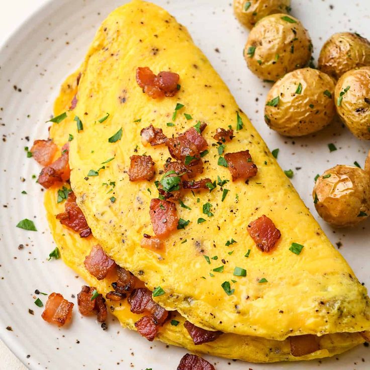 an omelet with bacon and potatoes on a plate