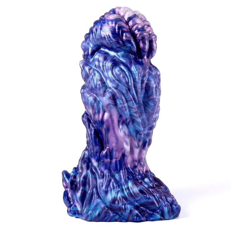 a purple and blue vase sitting on top of a white table