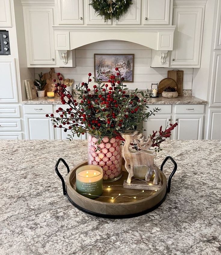 a tray with flowers and candles on top of a kitchen counter