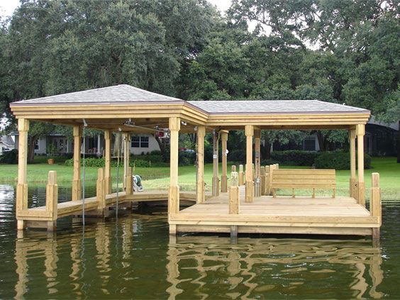 a wooden gazebo sitting on top of a body of water