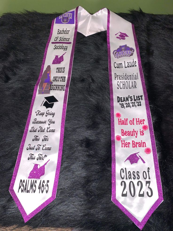 two purple and white graduation sashes on a black fur area with the words class of 2013