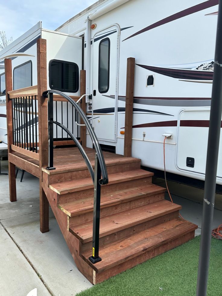 an rv parked next to a set of steps leading up to the front porch area