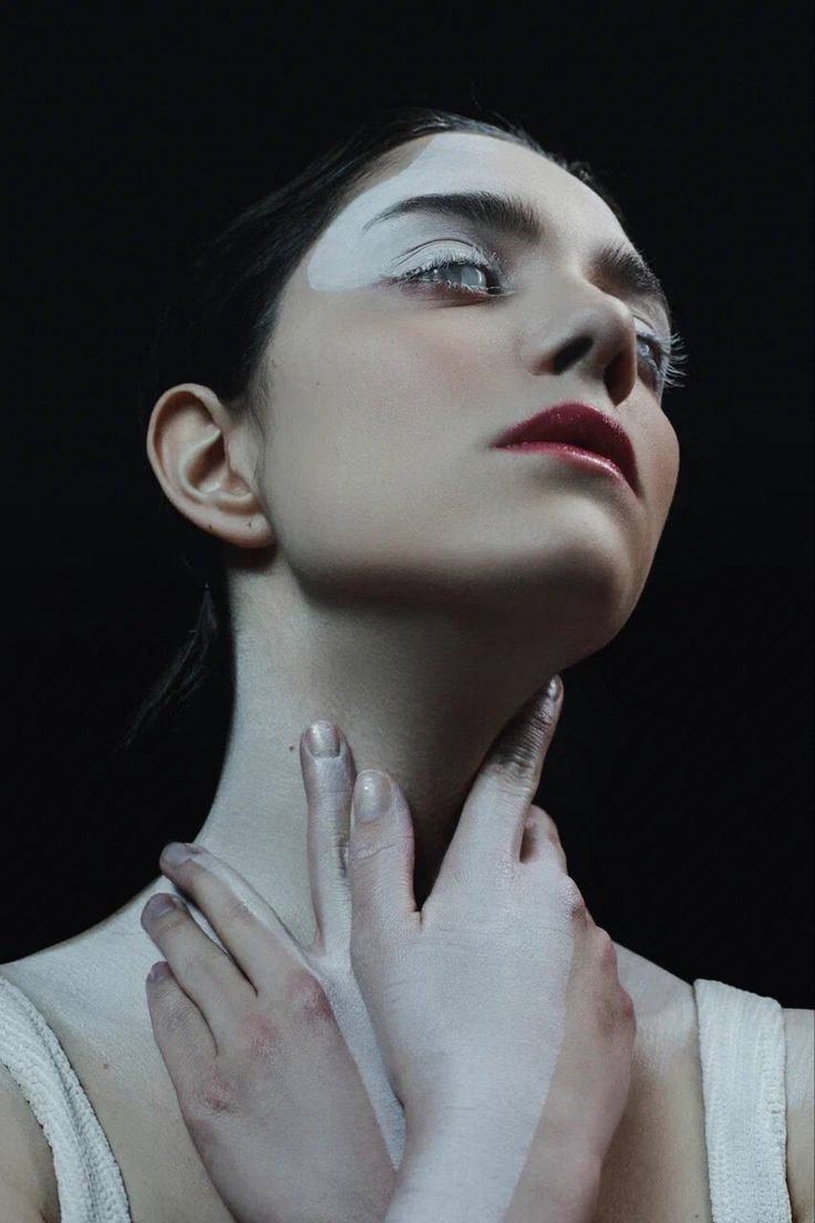 a woman with white paint on her face and hands