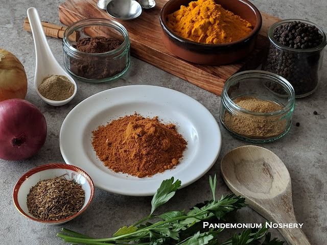 various spices are arranged on a table with wooden spoons and other ingredients in bowls