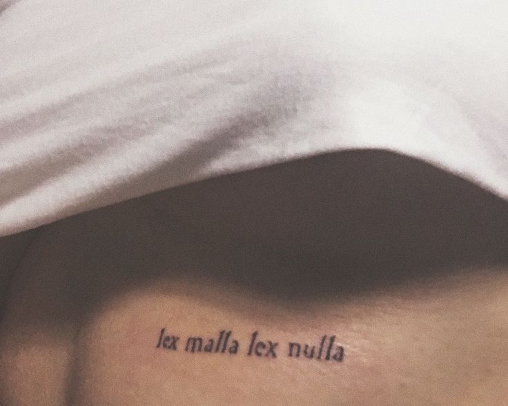 a woman with a tattoo on her stomach saying la malla tex nulla written in cursive font