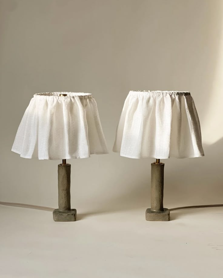 two lamps that are sitting next to each other on a white surface and one is turned off