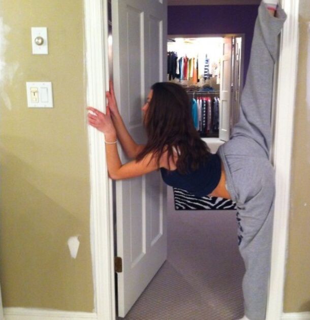 a woman standing on one leg in front of a door