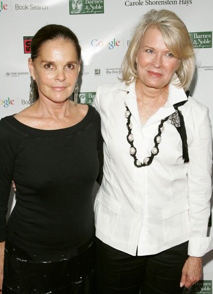 two women standing next to each other on a red carpet