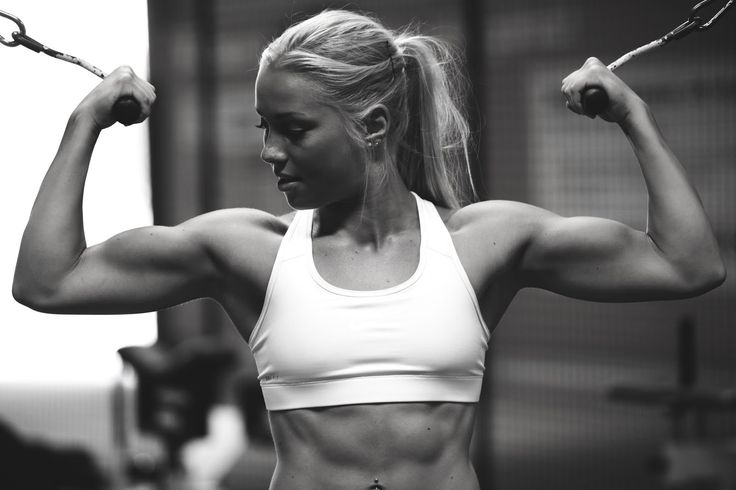 a black and white photo of a woman flexing her muscles