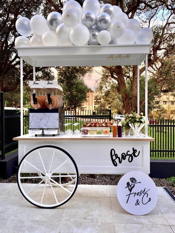 an outdoor ice cream stand with balloons on the roof and white cartage for sale