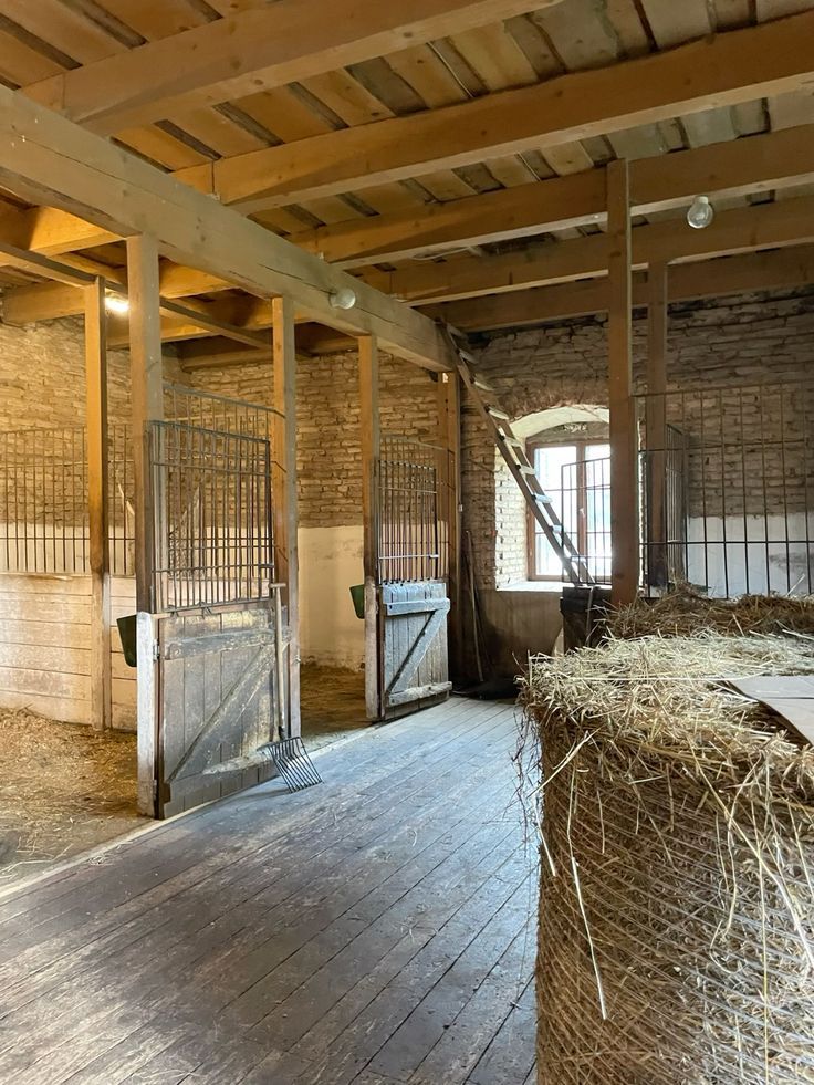 an old barn with hay bales in the floor