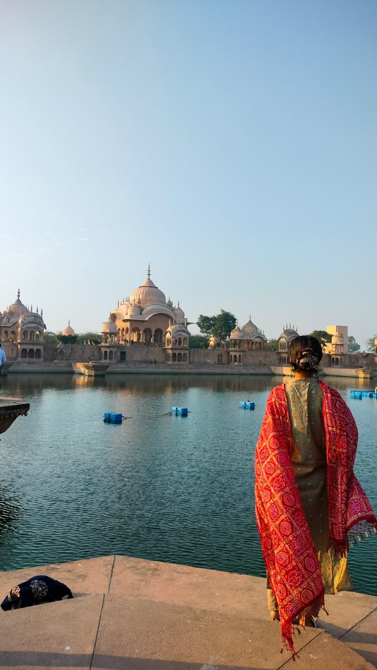 a woman standing on the edge of a lake