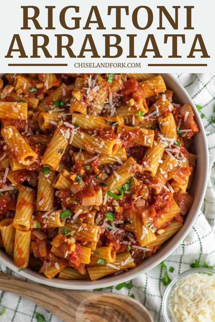 rigattoni with meat and sauce in a white bowl next to a wooden spoon