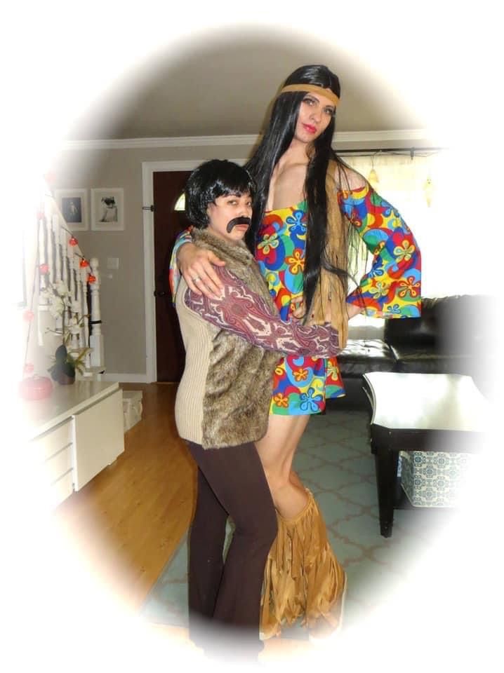 a woman is hugging a man in a living room with a piano behind her on the floor