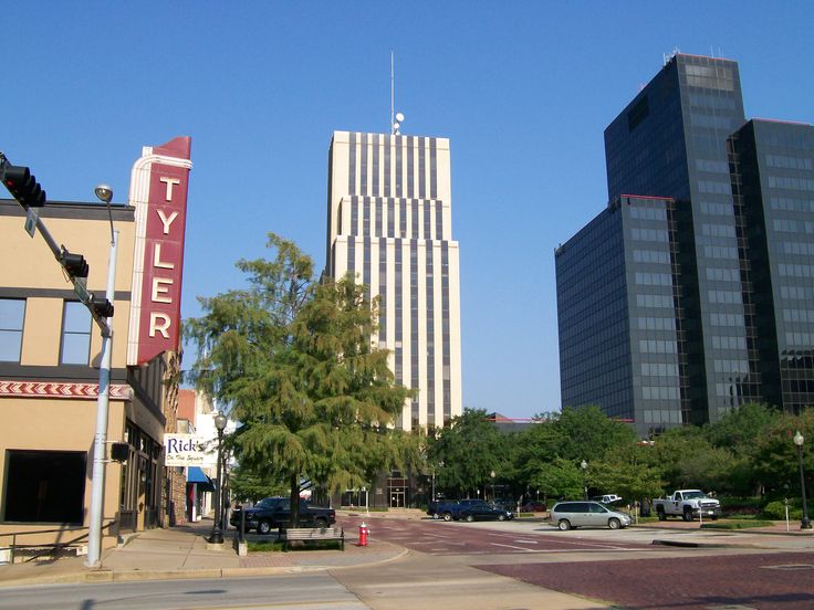 a city street with tall buildings in the background